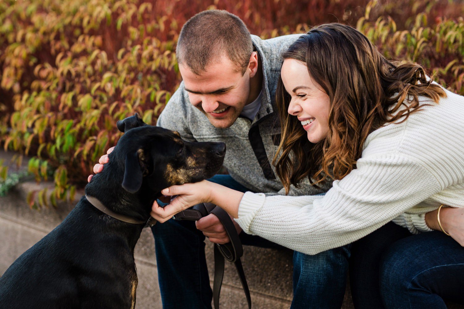 a couple with their dog at their engagement session at University of Washington in Seattle