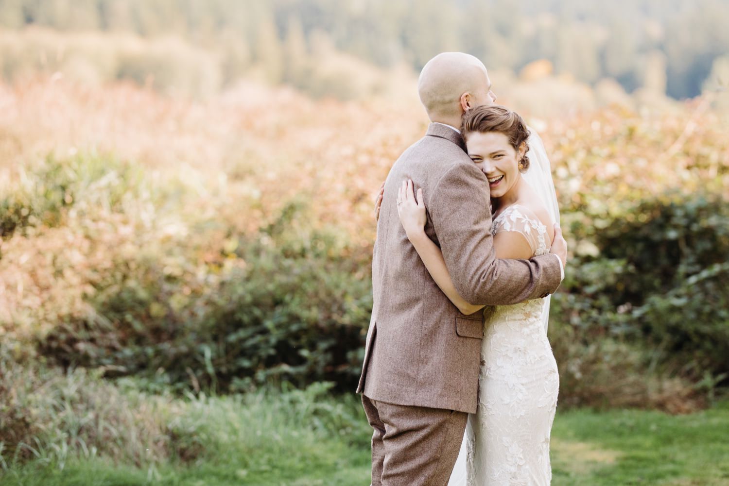 couple embracing during their first look at fireseed catering wedding venue on whidbey island