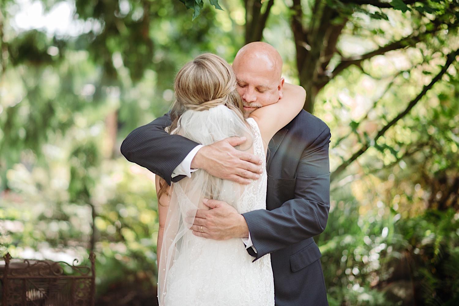 first look with bride and father hugging at Pine Creek Farms and Nursery wedding venue un Monroe, Washington