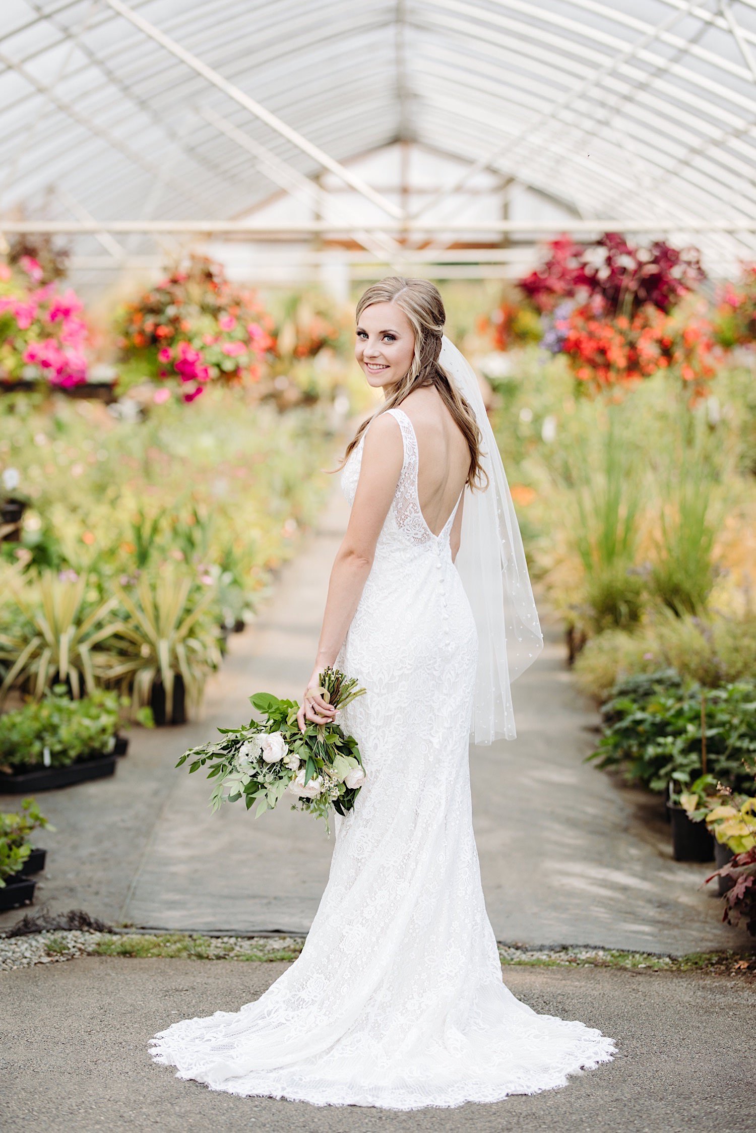 bride standing in front of a flower greenhouse at Pine Creek Farms and Nursery wedding venue near Seattle Washington