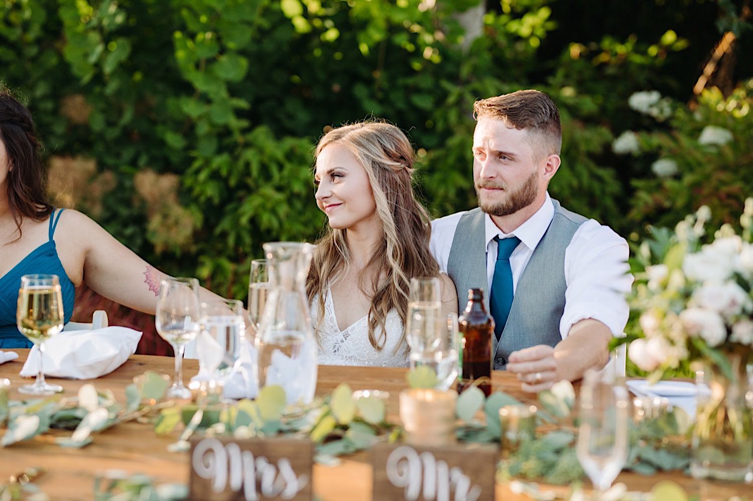 wedding couple listening to speeches at outdoor reception at Pine Creek Farms and Nursery in Monroe, Washington