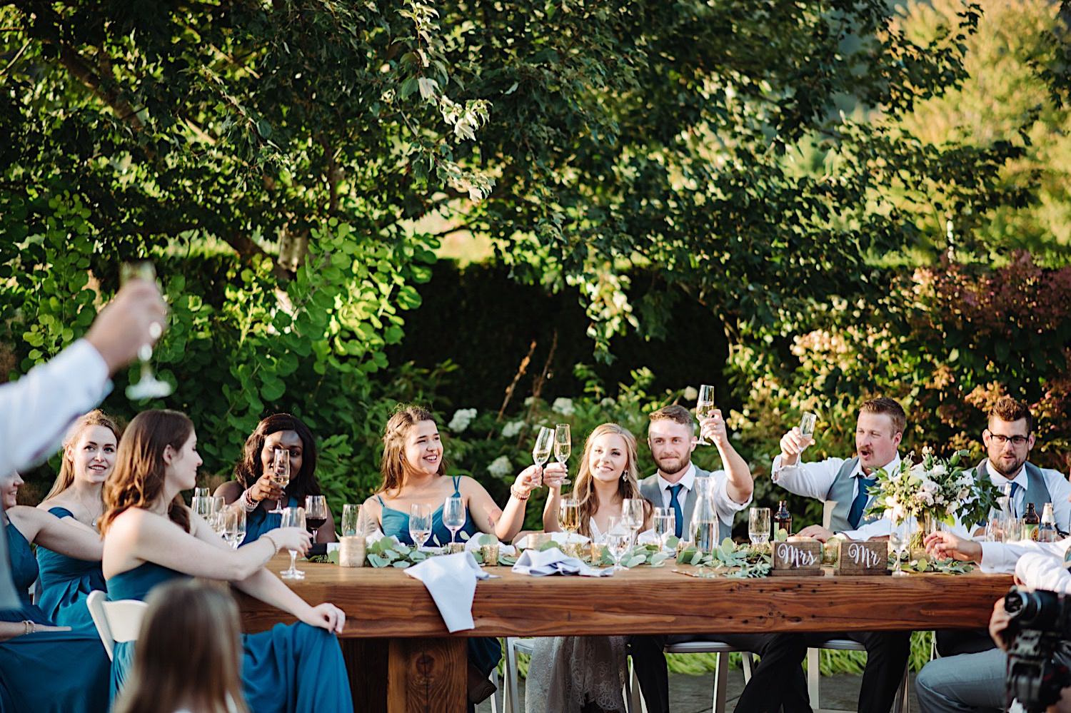 wedding party toasting with champagne at outdoor wedding reception at Pine Creek Farms and Nursery in Washington State