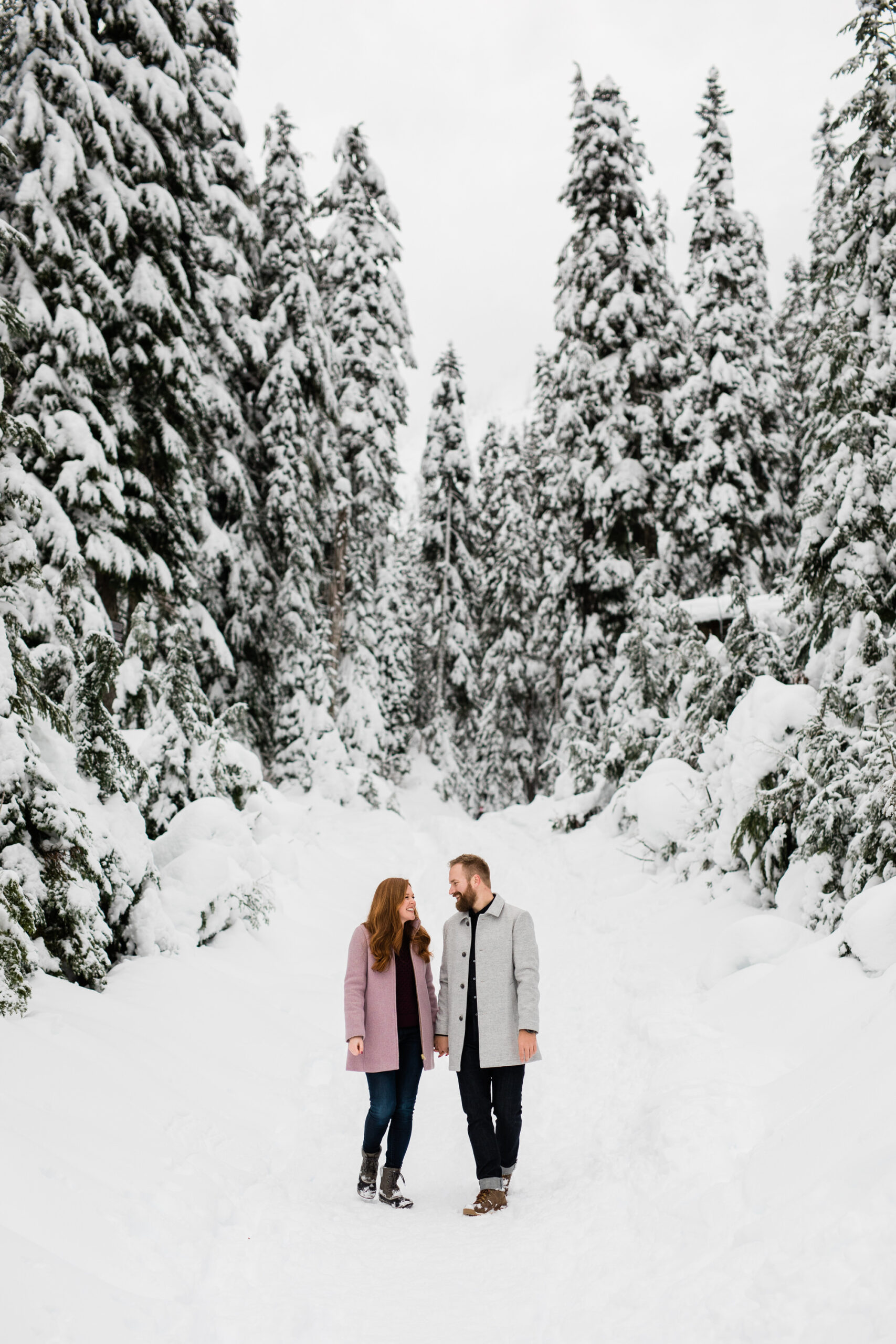 Couple walks together in the snow.