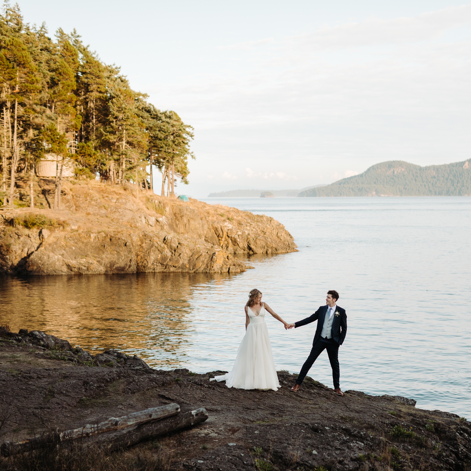 couple holding hands on rocky beach at Doe Bay resort on Orcas Island
