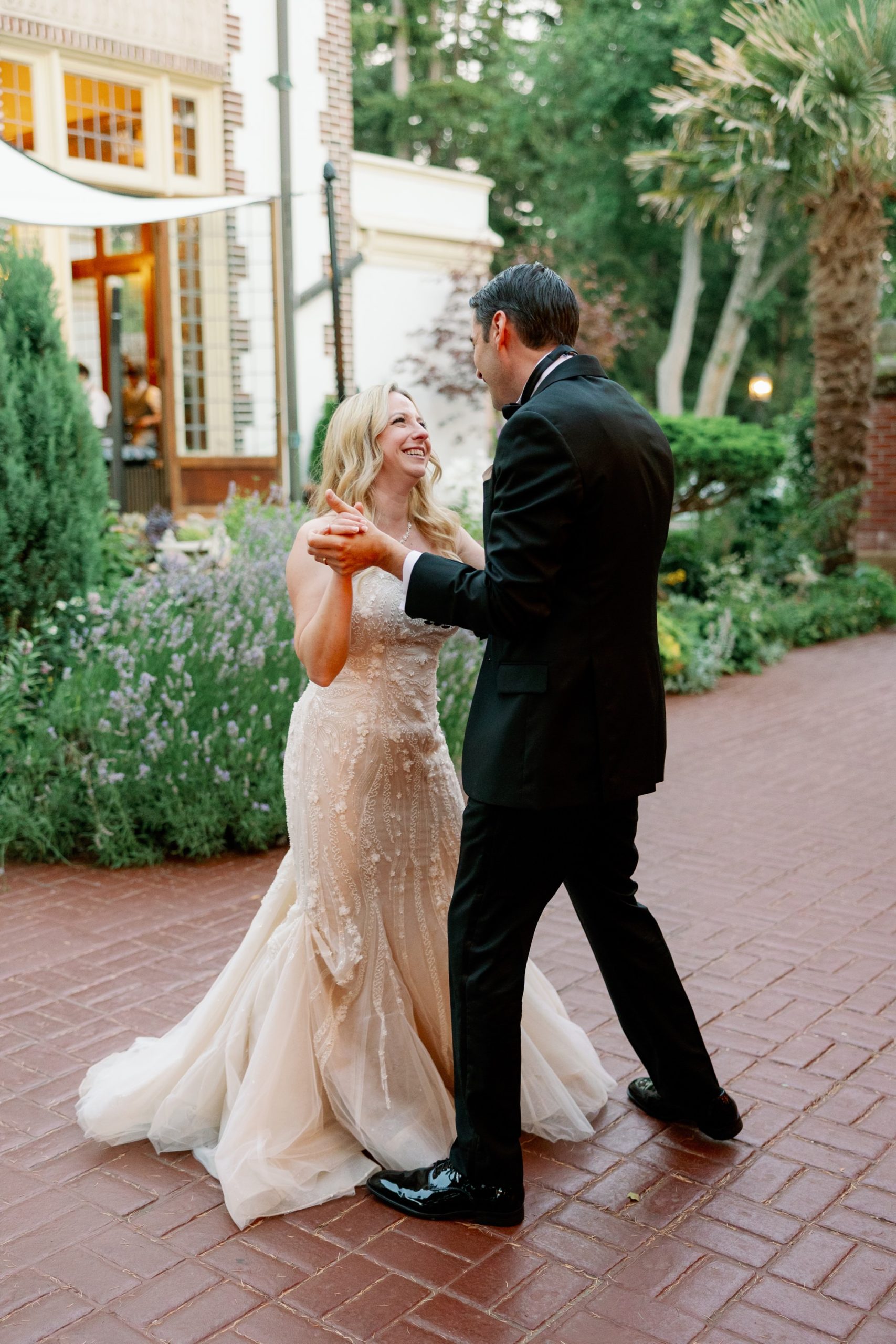 A wedding couple smiles at each other during their first dance outside at Lairmont Manor.