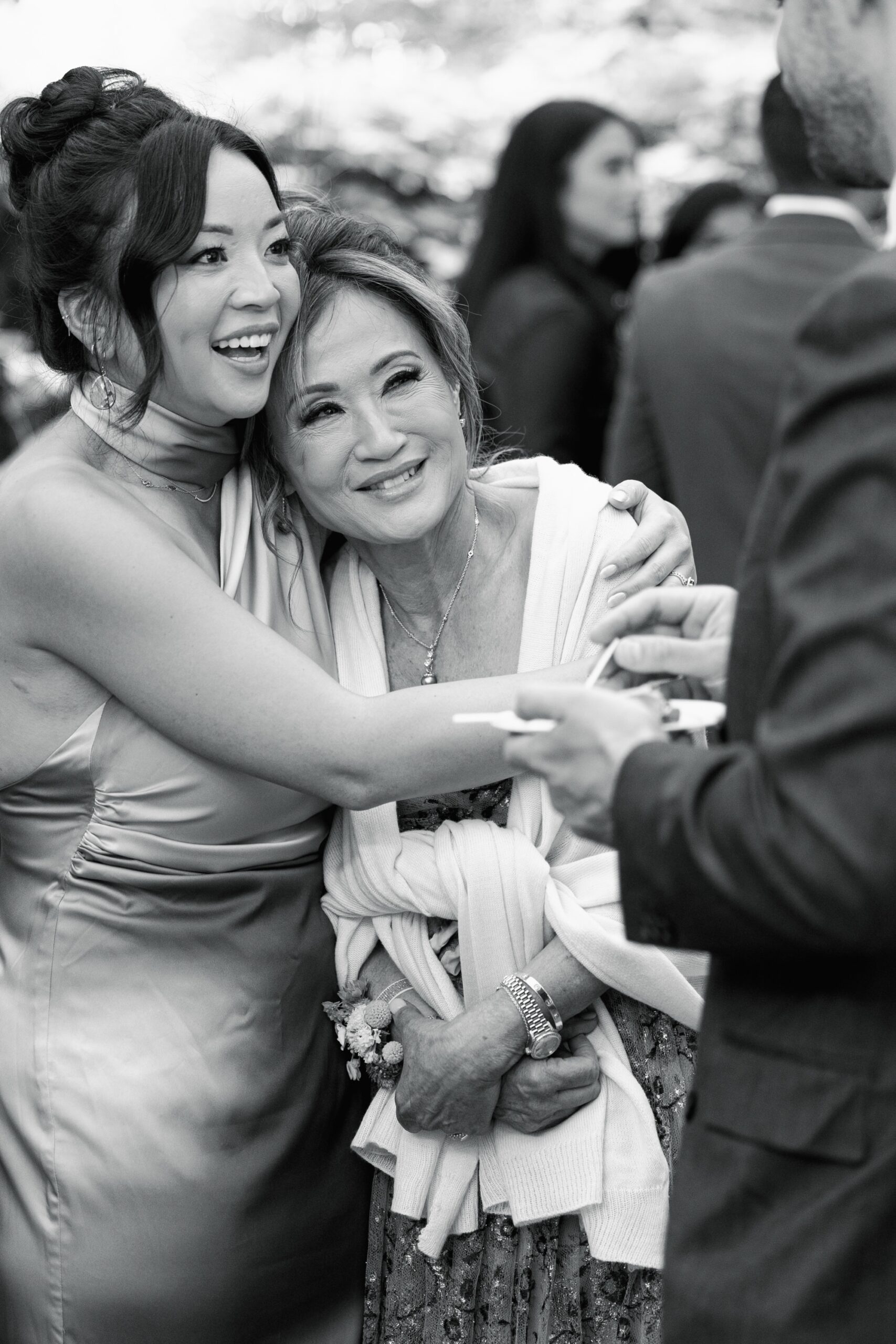 Wedding guests hug at cocktail hour