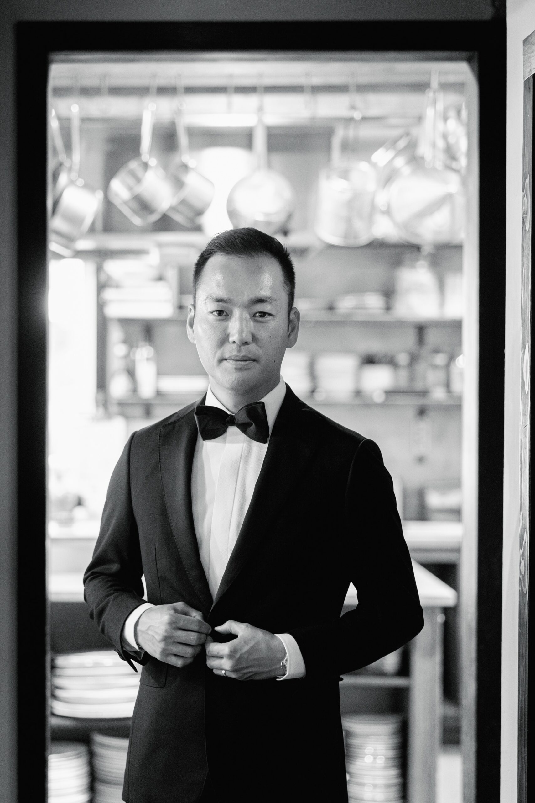 The groom stands in front of the kitchen at the Corson Building