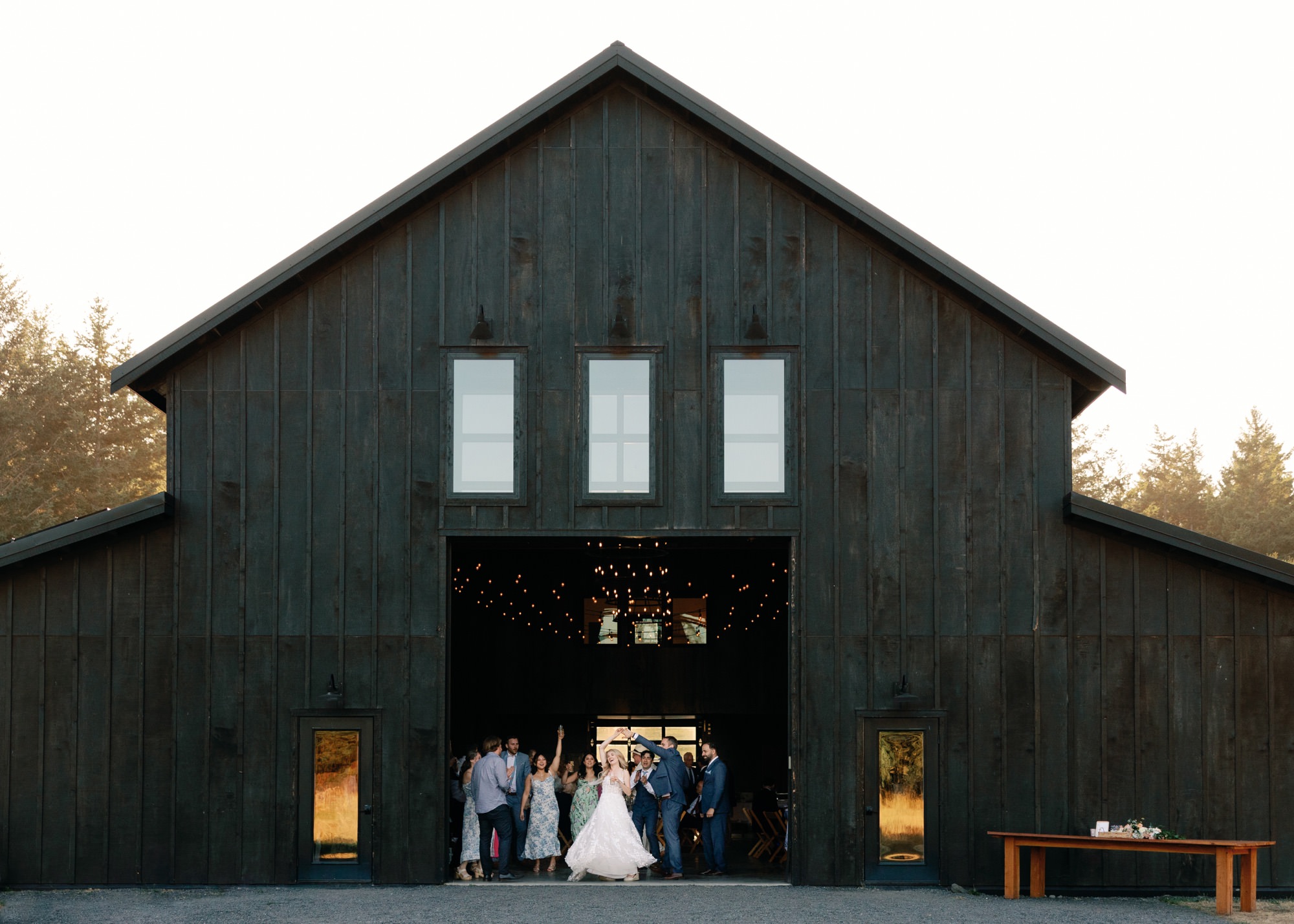 A couple and their wedding guests dance inside the barn at Saltwater Farm on San Juan Island.