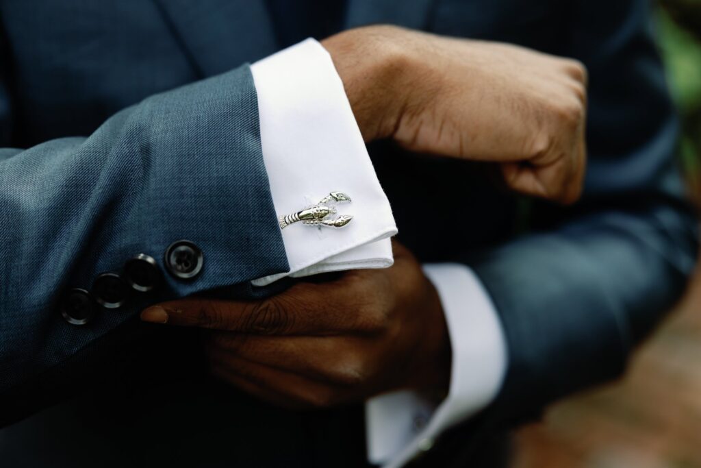 Close-up of groom's cufflinks shaped like lobsters