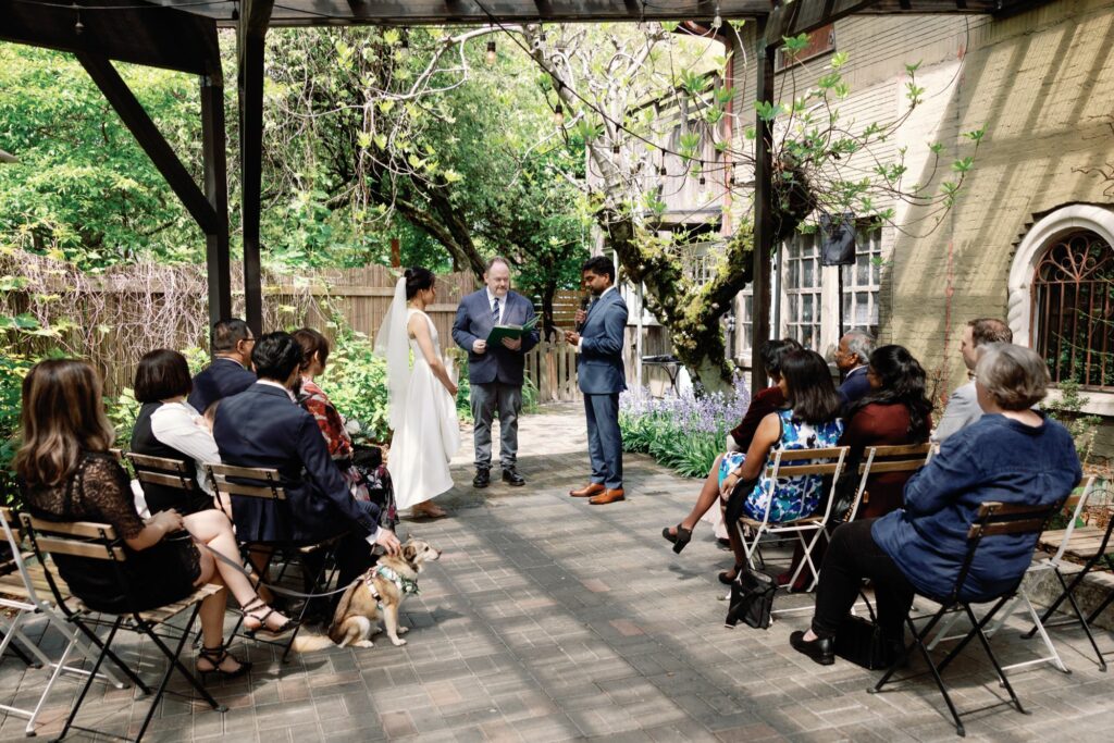 The bride and groom exchanging vows in an outdoor garden ceremony.
