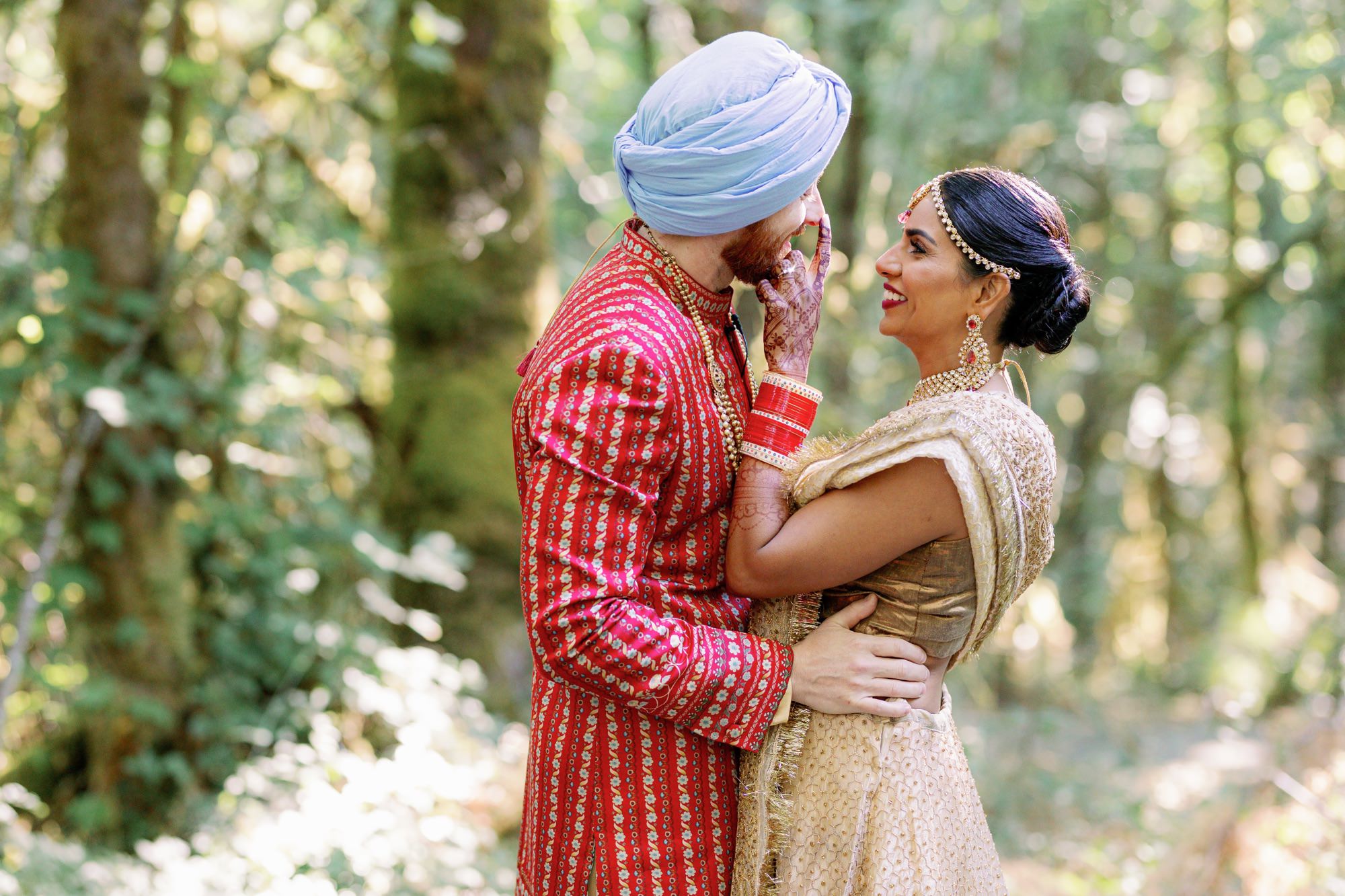 Bride and groom sharing a joyful moment in the woods