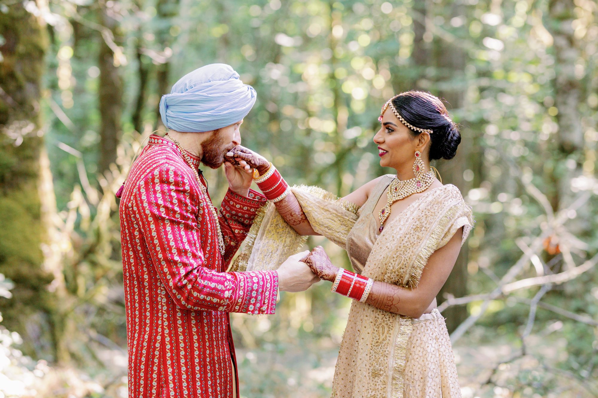 Groom kissing bride's hand with henna