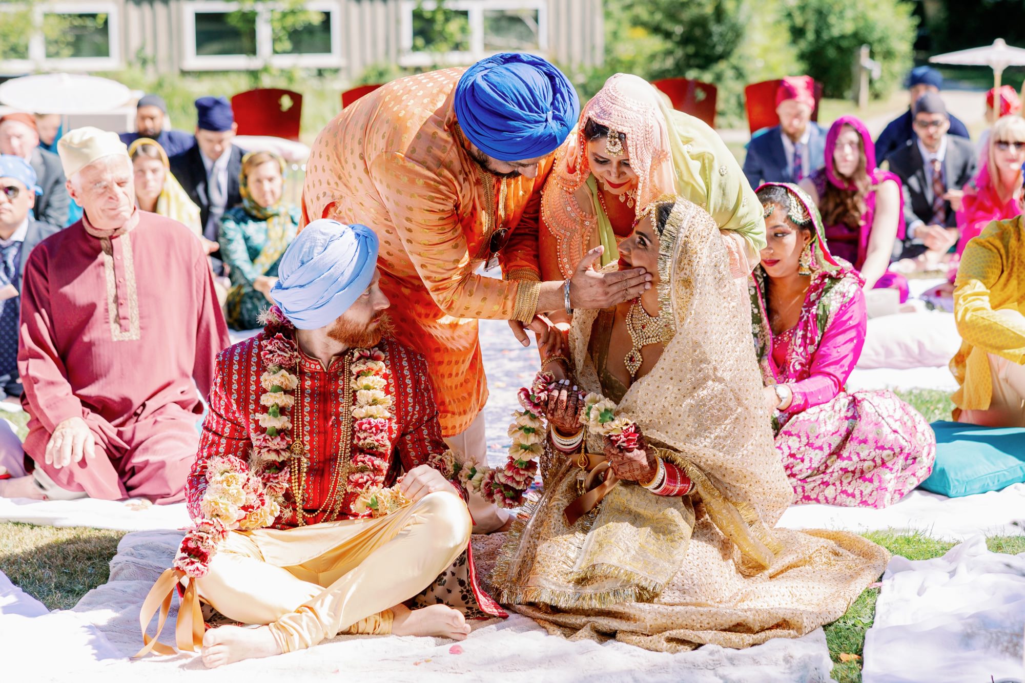 The bride's family blesses the couple during the wedding ceremony, creating an emotional moment.