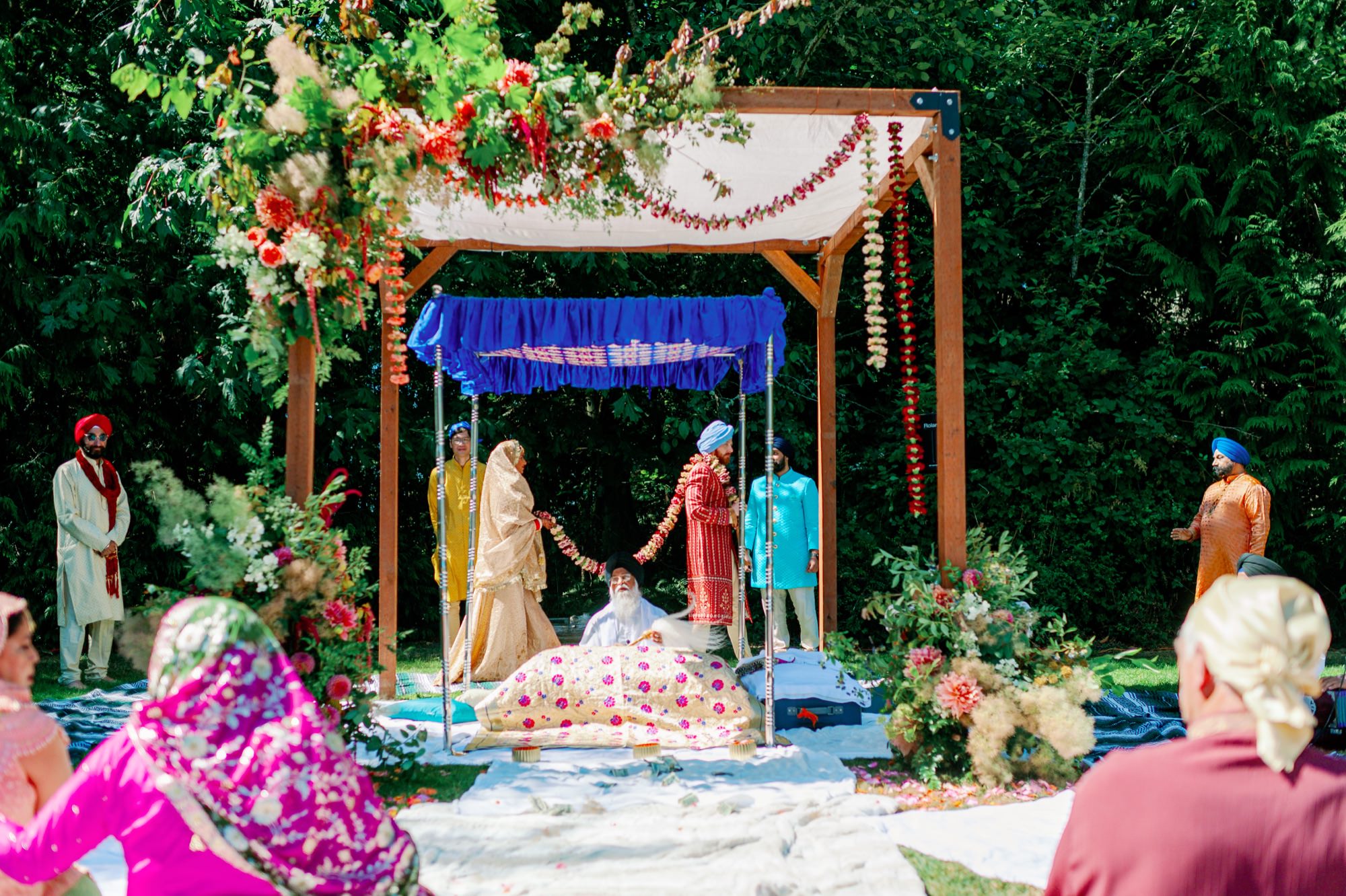 The bride and groom participate in a traditional ritual under a beautifully decorated canopy.