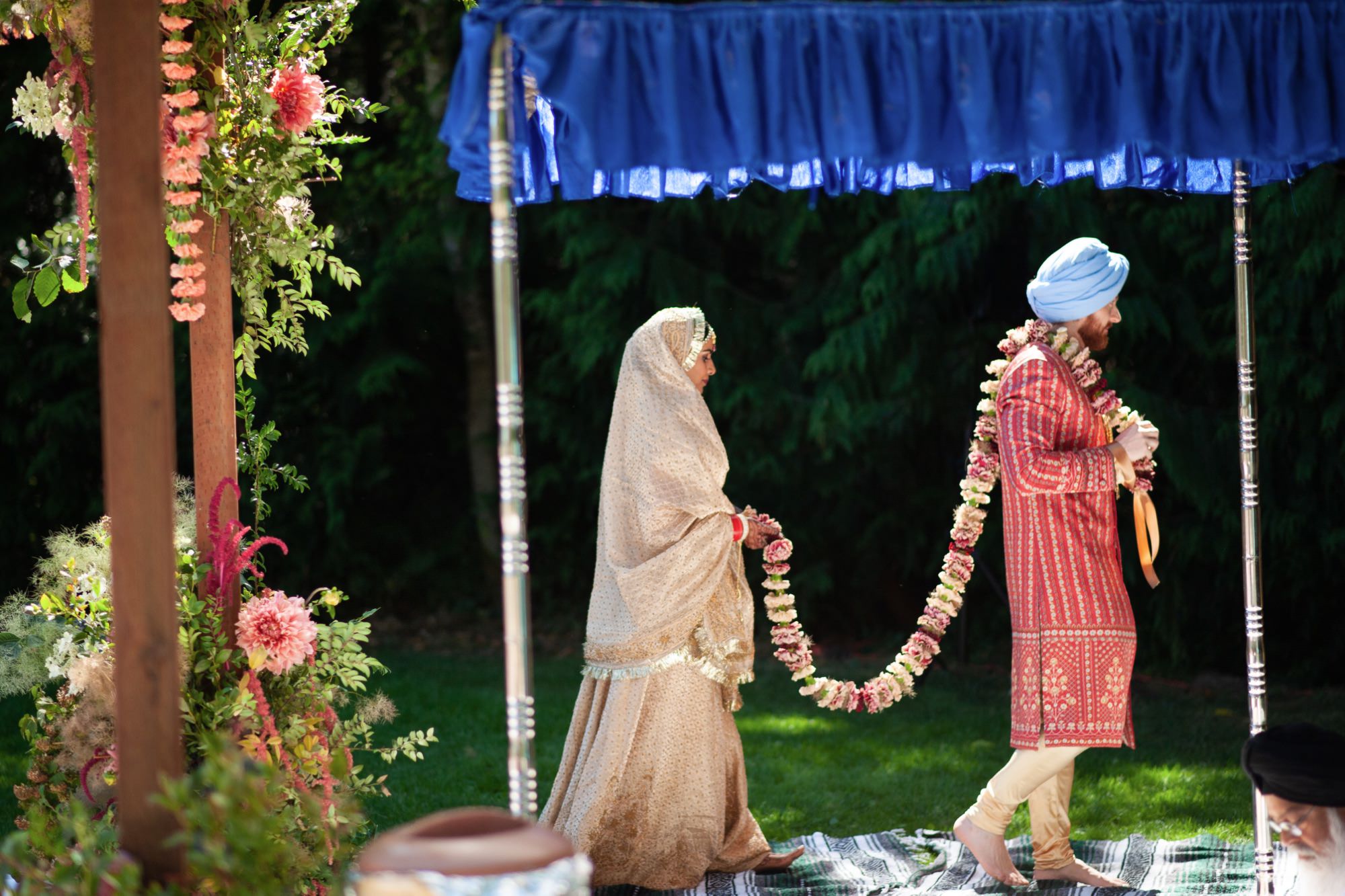 The bride and groom walk together under the ceremonial canopy, performing traditional rituals.