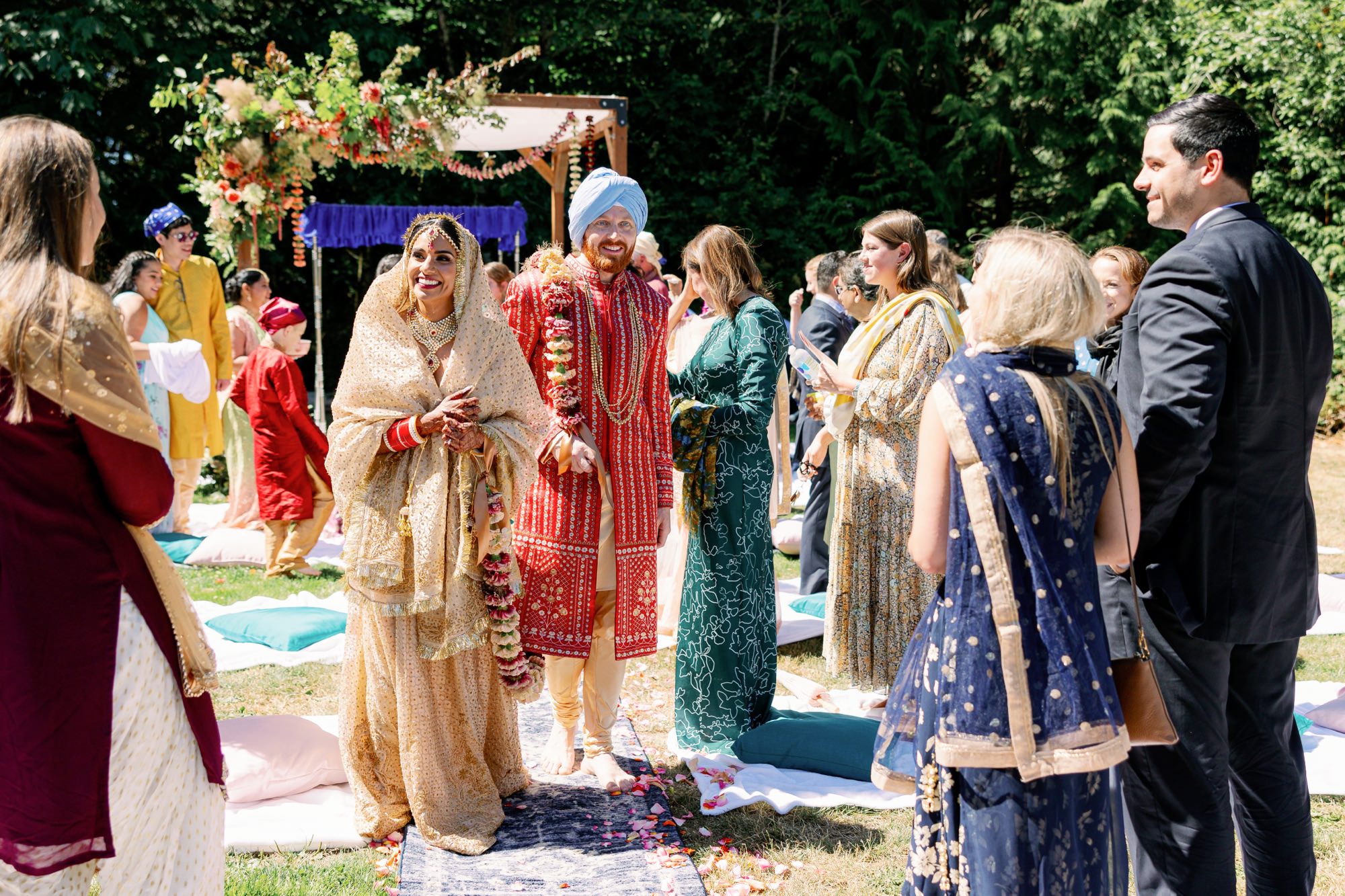 Bride and groom walking down the aisle, smiling and surrounded by guests.