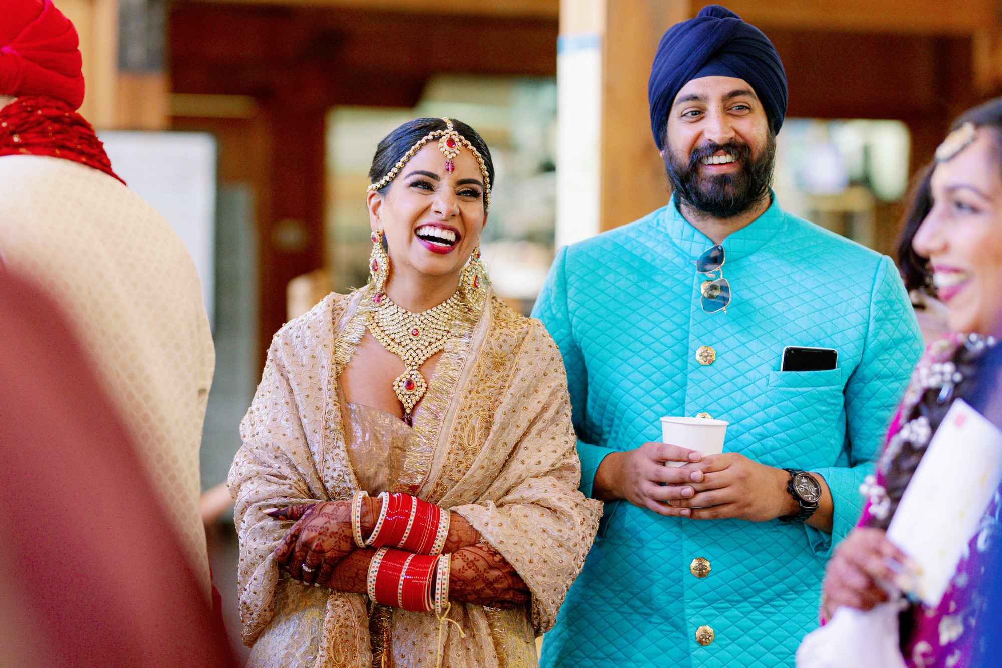 Bride and groom laughing and enjoying the wedding reception with friends.