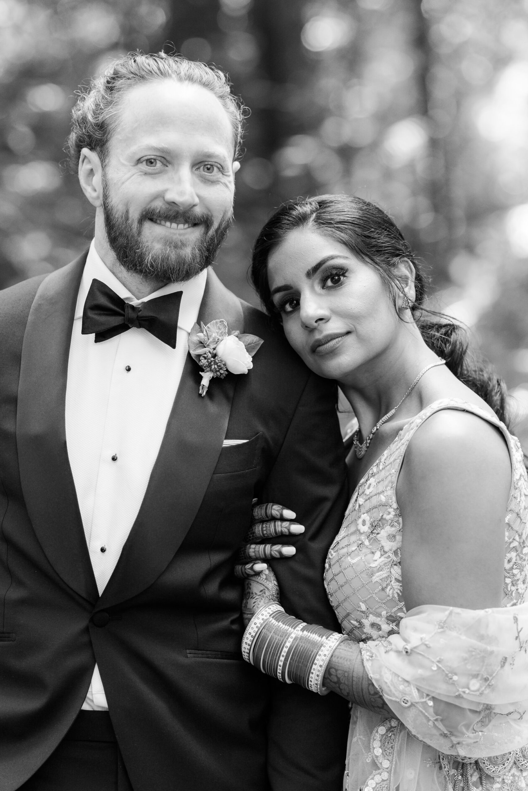 Black and white portrait of the couple, bride leaning on the groom's shoulder.