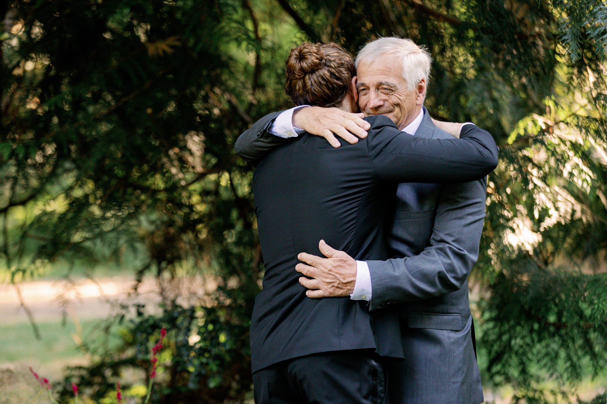 Emotional embrace between groom and his father.