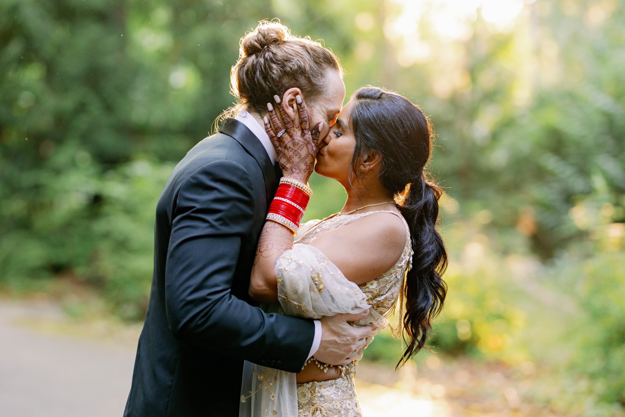 Bride and groom sharing a romantic kiss in a glow of the golden sun. 