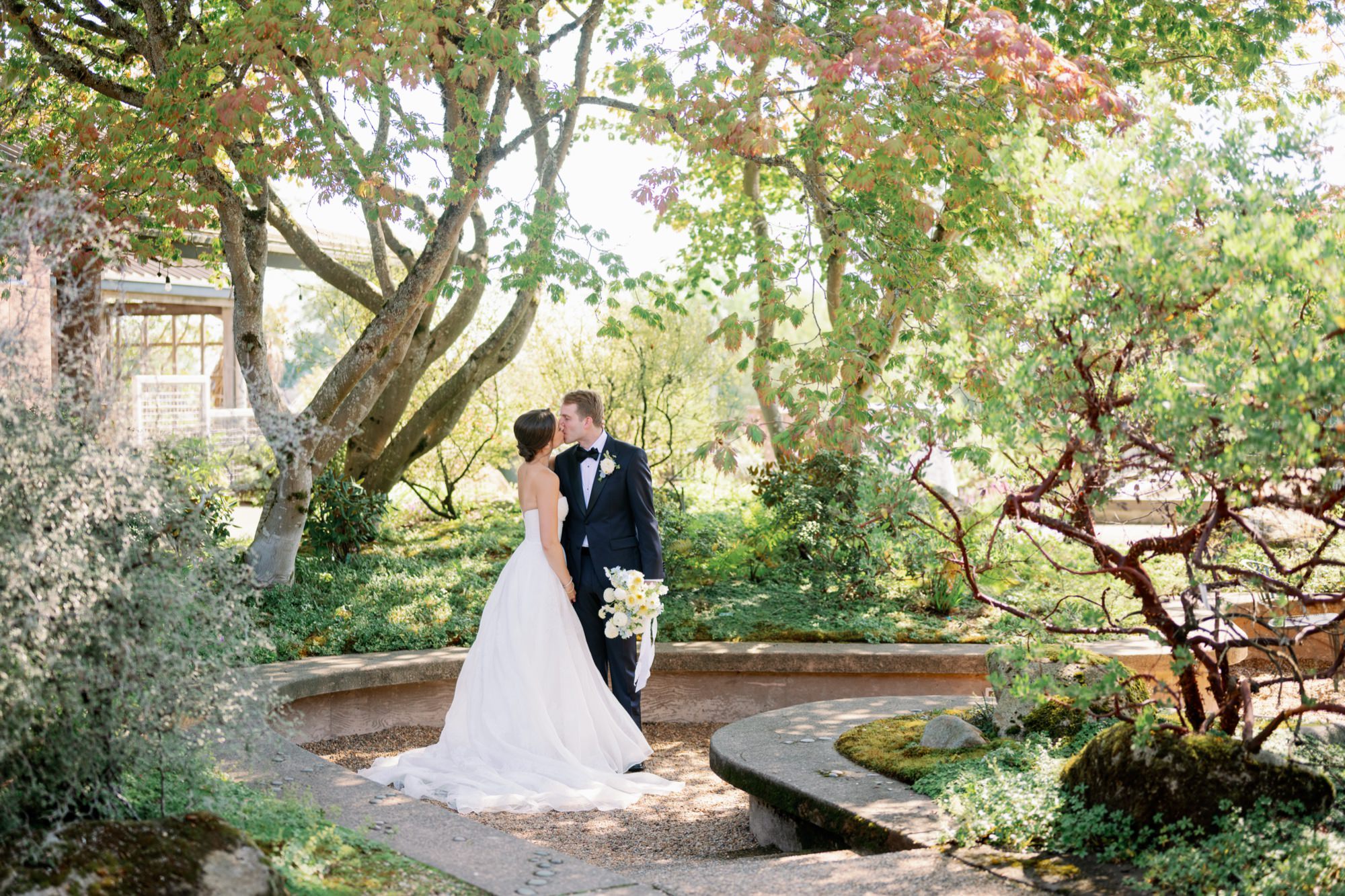 Couple kisses in McVay Courtyard at their wedding at Center for Urban Horticulture
