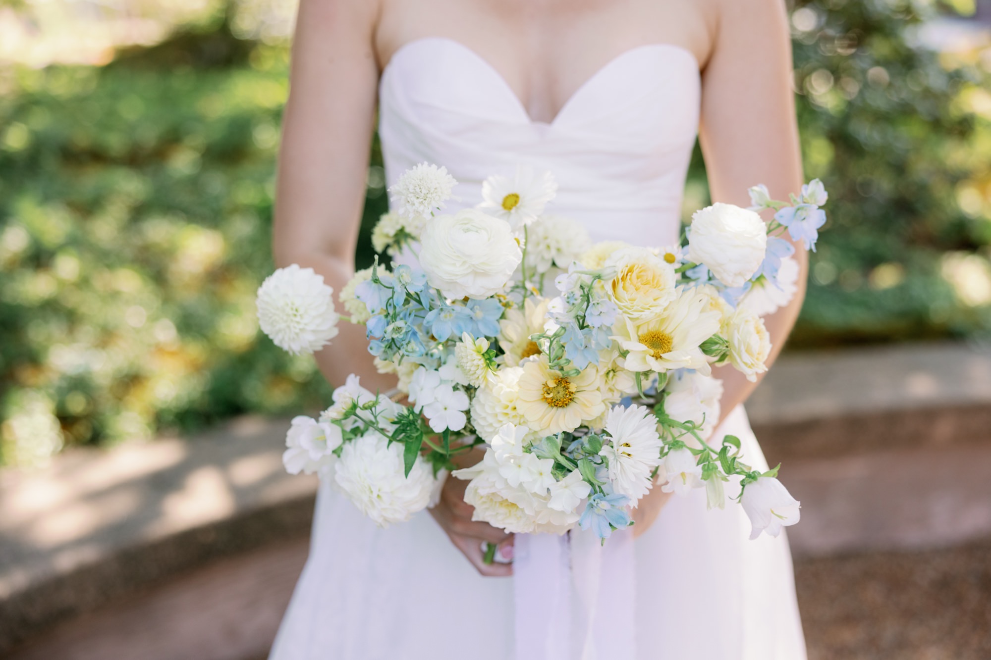 closeup of wedding bouquet with white and soft yellow and blue flowers.