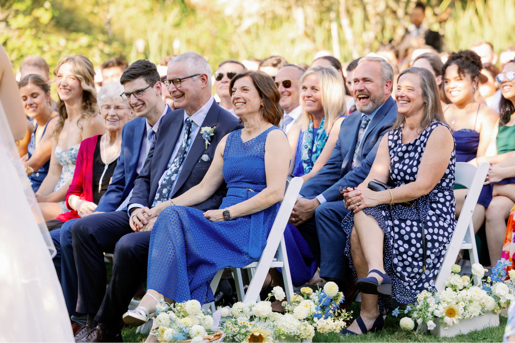 Wedding guests laugh during the ceremony.
