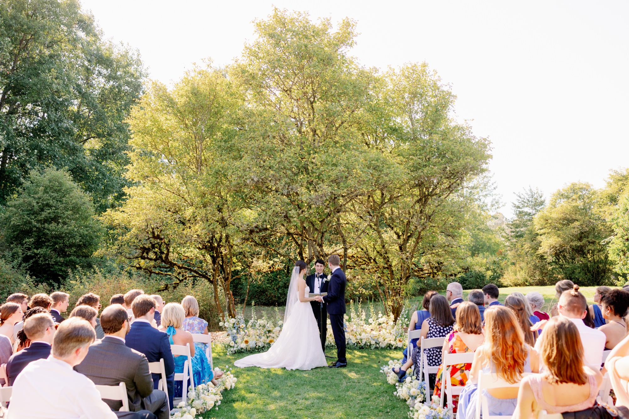 Guests look on as wedding couple get married in the meadow at Center for Urban Horticulture