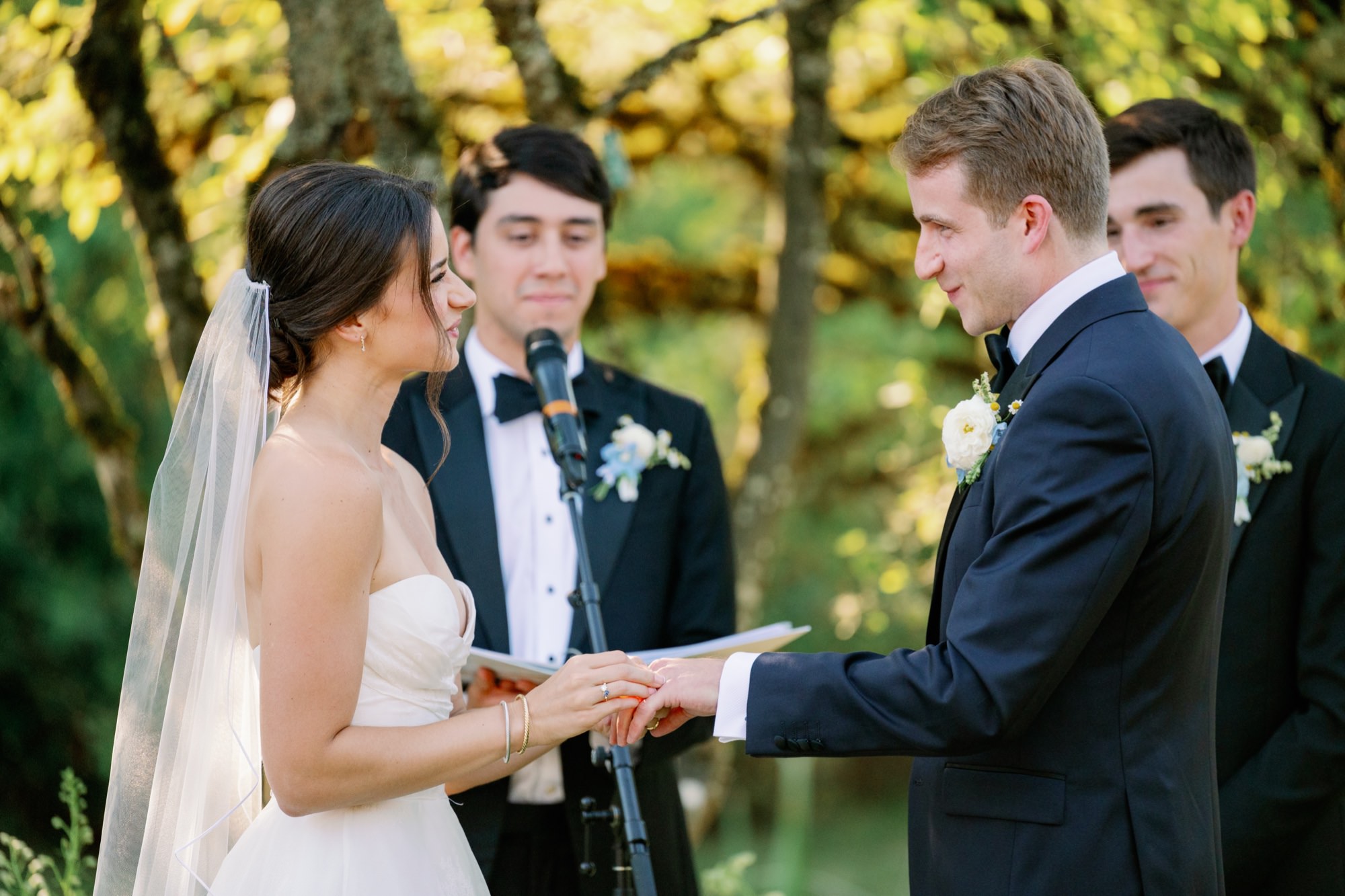 The couple exchanges rings during their outdoor ceremony.