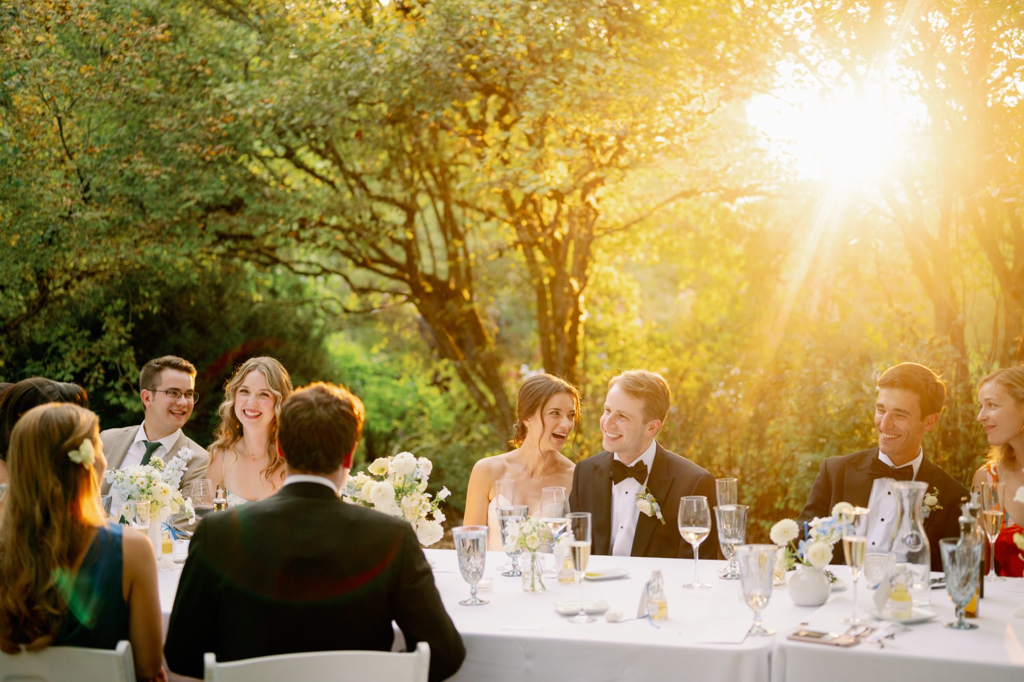 Golden light filters through the trees into Goodfellow Grove during dinner at a wedding at Center for Urban Horticulture.