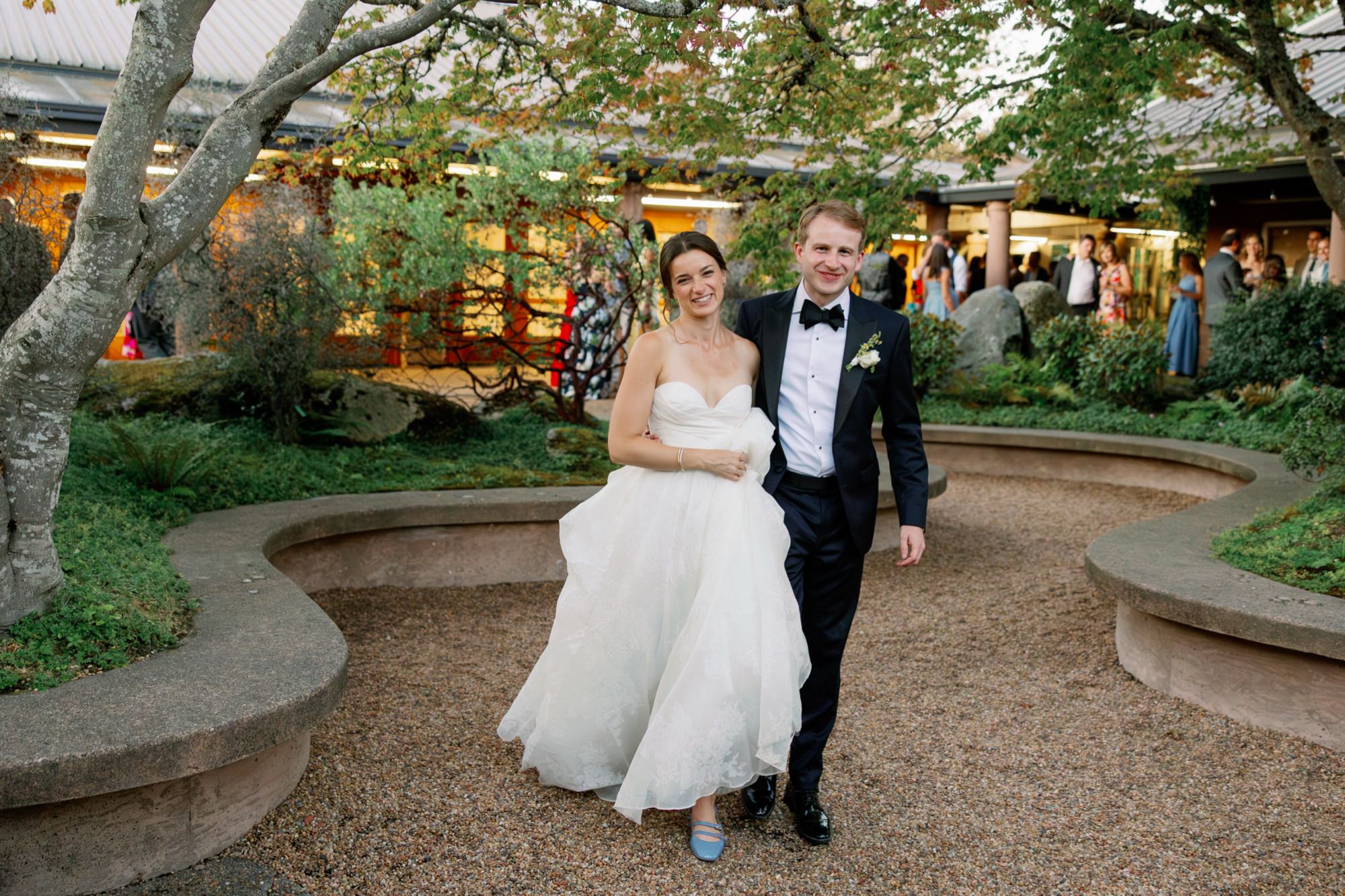The couple walks through the courtyard on their way to the atrium for cake and dancing at the Center for Urban Horticulture.