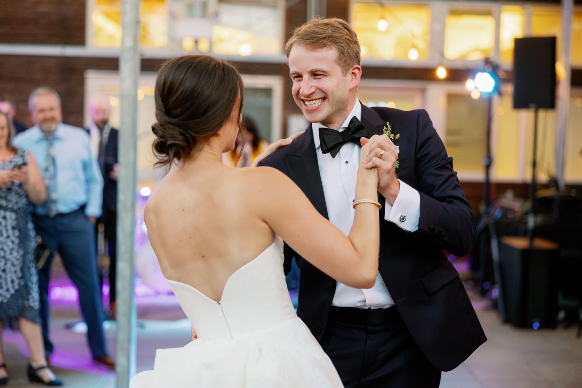 The couple shares a dance in the atrium while guests watch and celebrate.