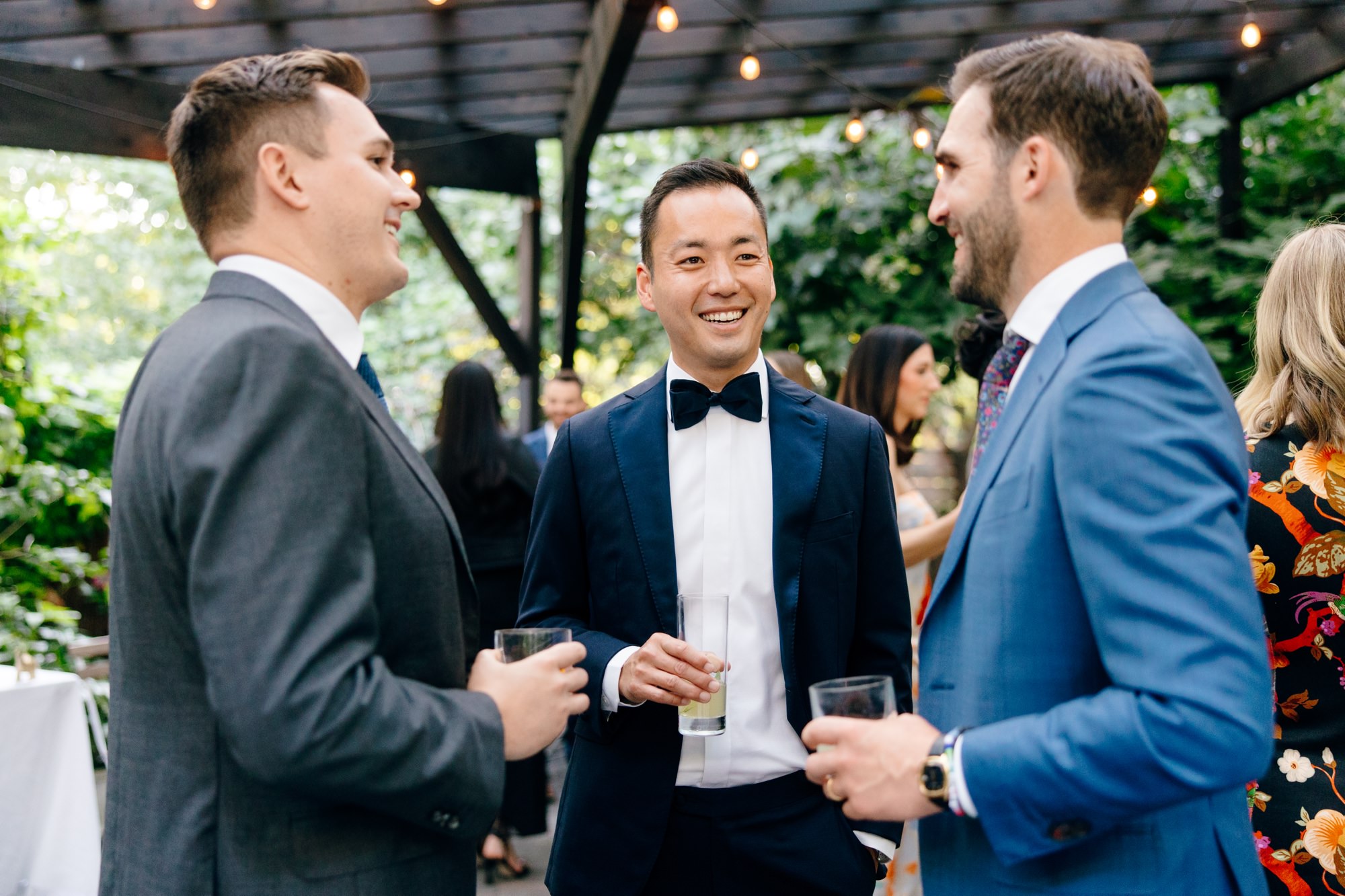 Guests enjoying a relaxed cocktail hour in the garden at The Corson Building, with drinks and conversation