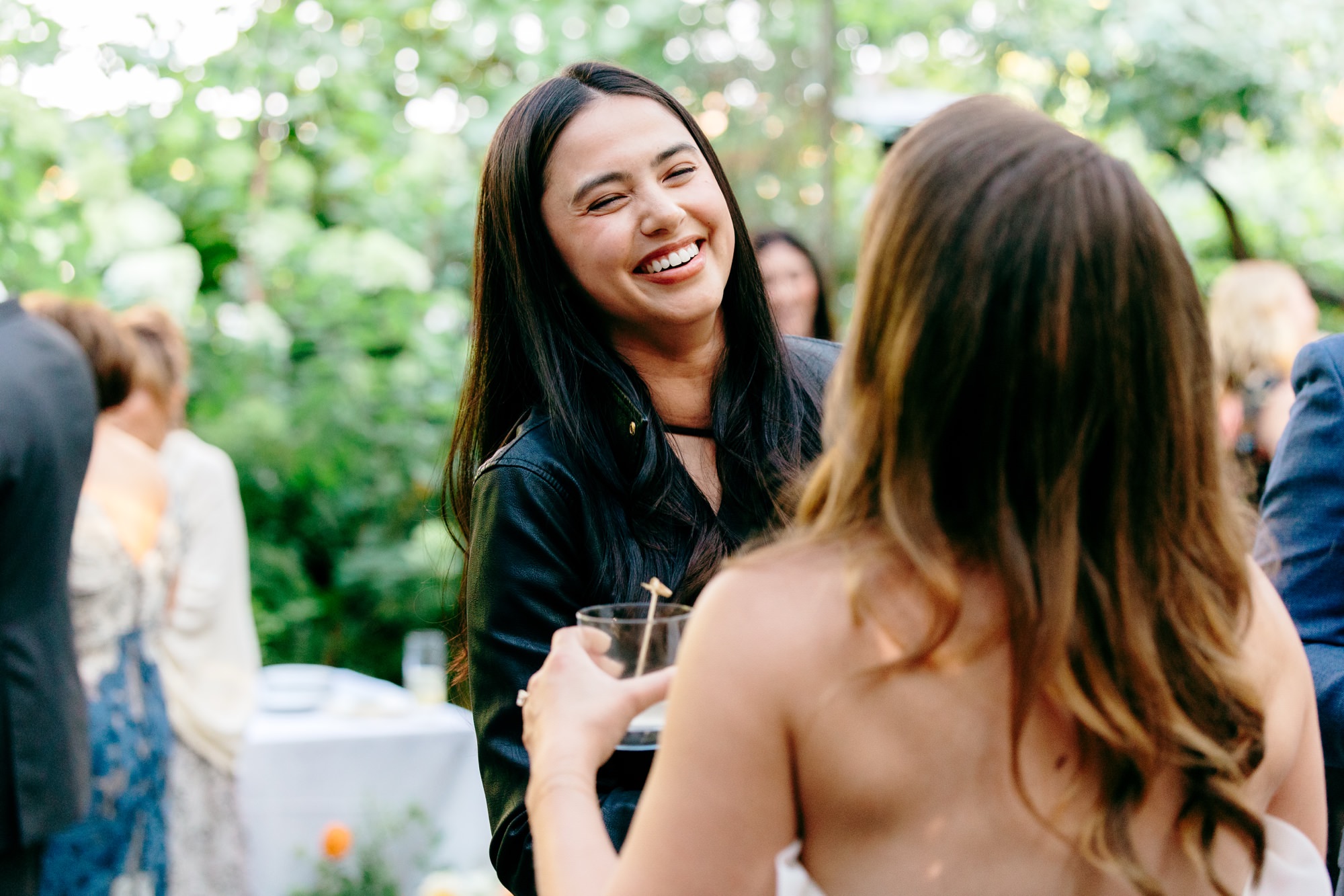 A wedding guest laughs and celebrates with the bride.