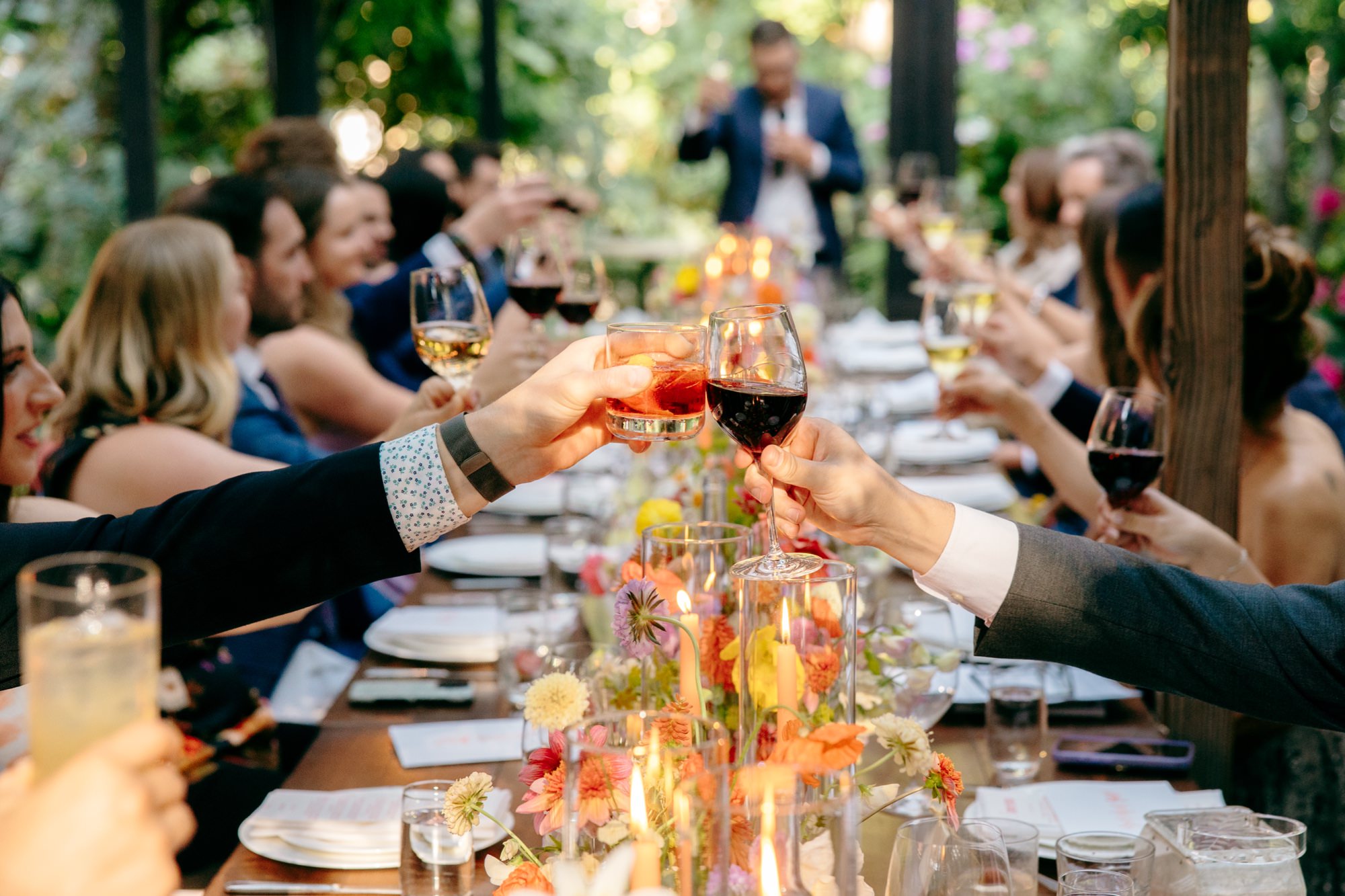 Wedding guests hold up their glasses and toast the newlyweds