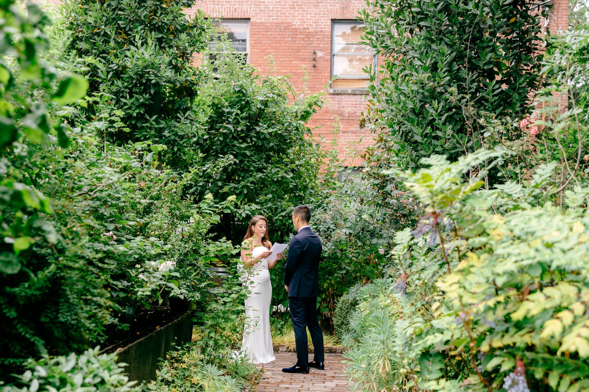 Bride reads vows in the garden at the Corson Building