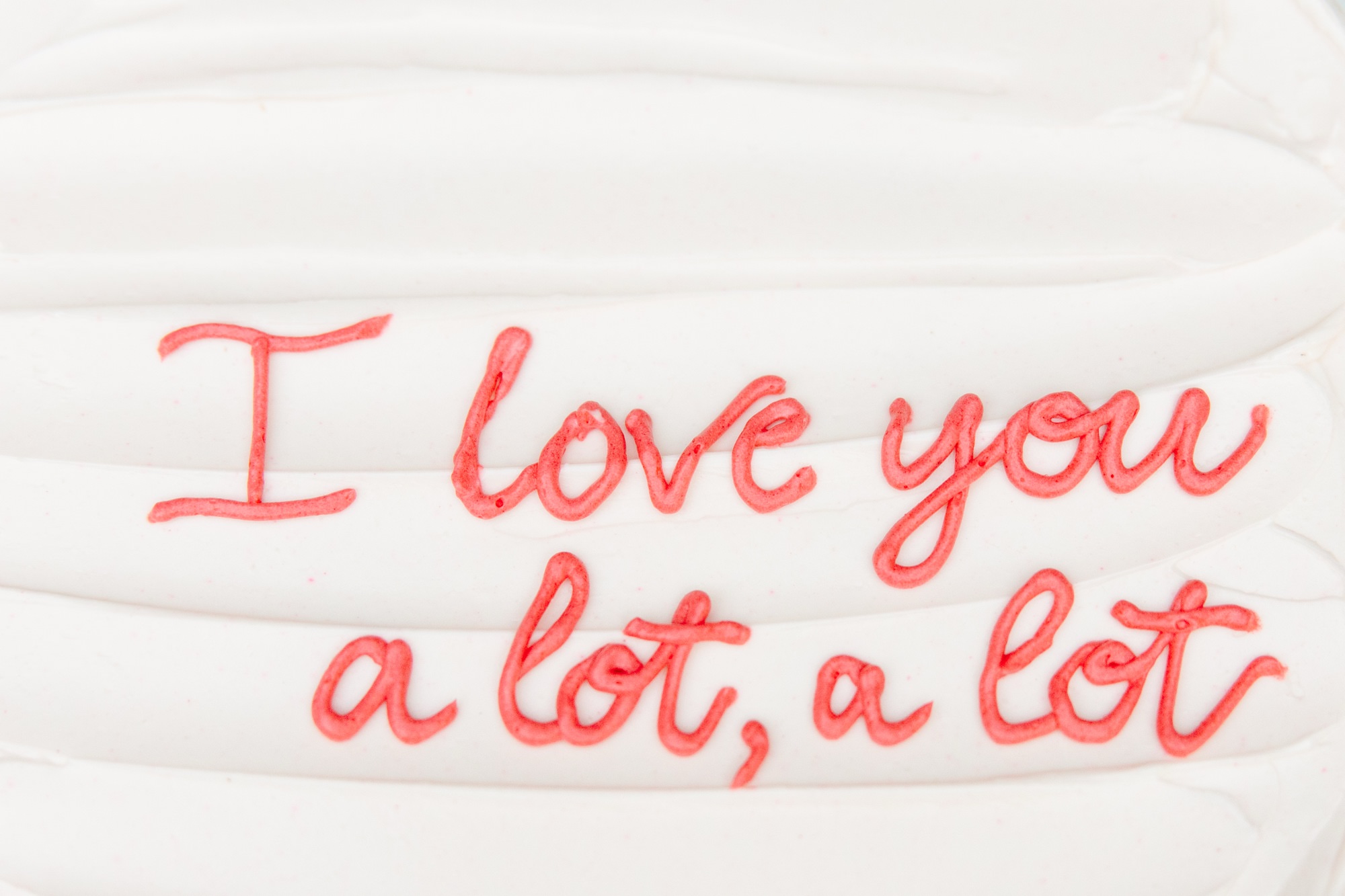 Close-up of wedding cake with hand-written text that says I love you a lot, a lot