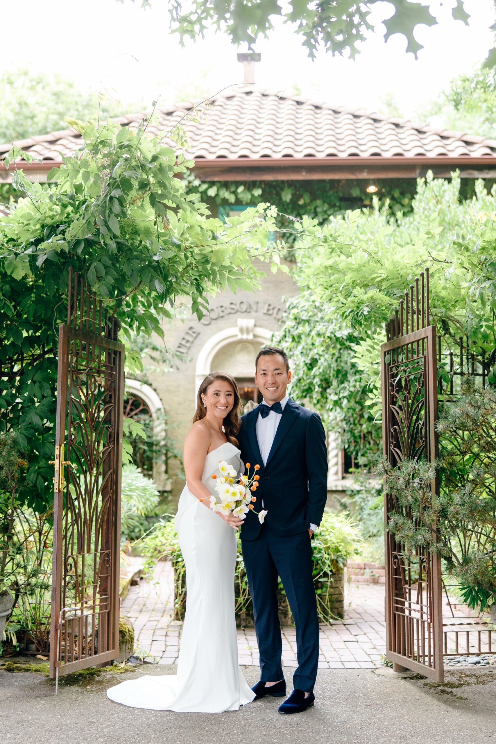 Wedding couple poses in front of The Corson Building at their Seattle wedding.