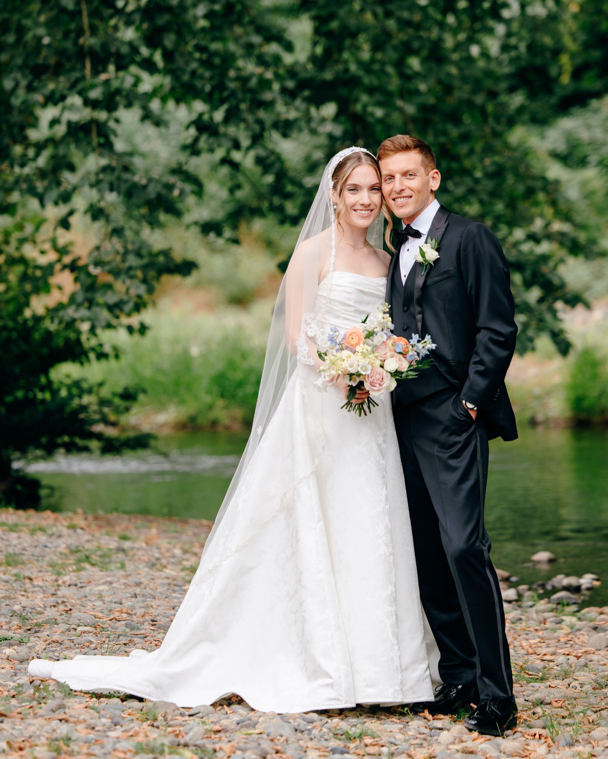 Bride and groom standing by the creek at Fox Hollow Farm, a Seattle wedding venue with natural greenery and outdoor charm.