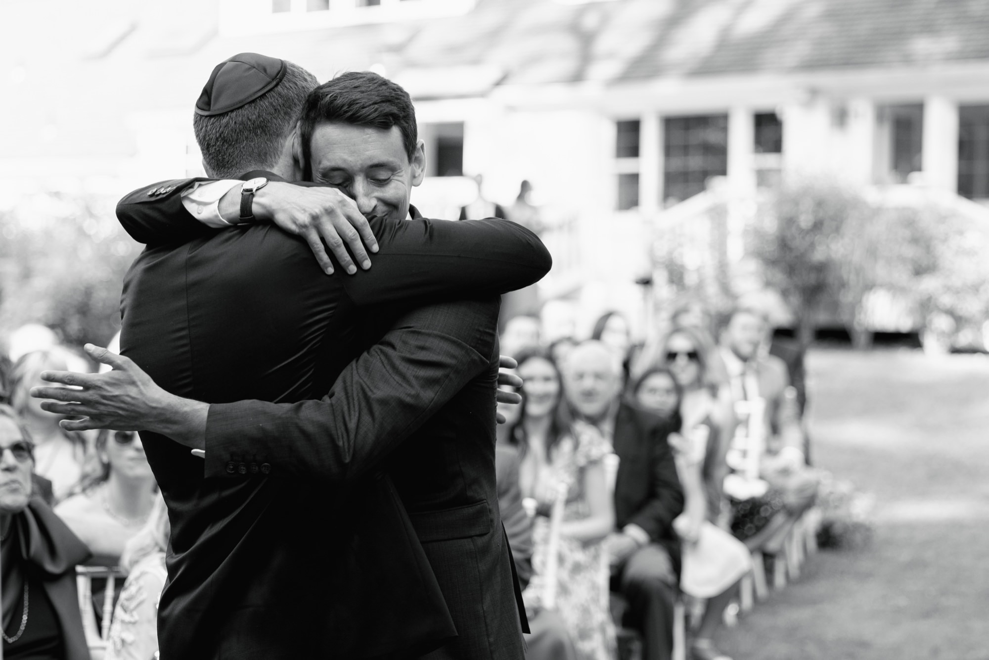 An emotional hug between the groom and groomsman at a Fox Hollow Farm wedding.