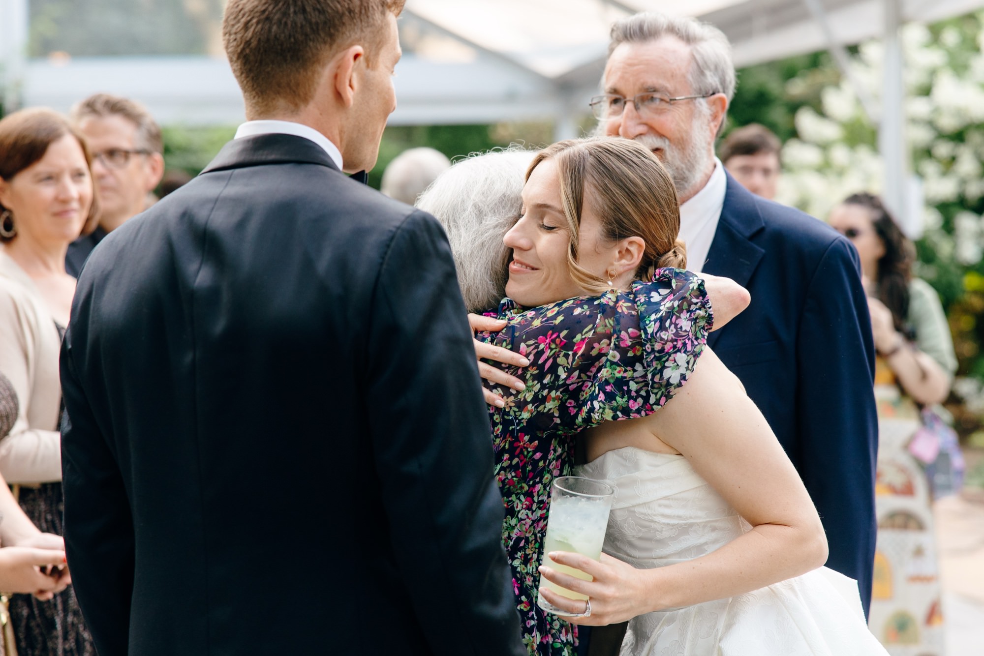 A wedding guest hugs the bride during cocktail hour at Fox Hollow Farm.