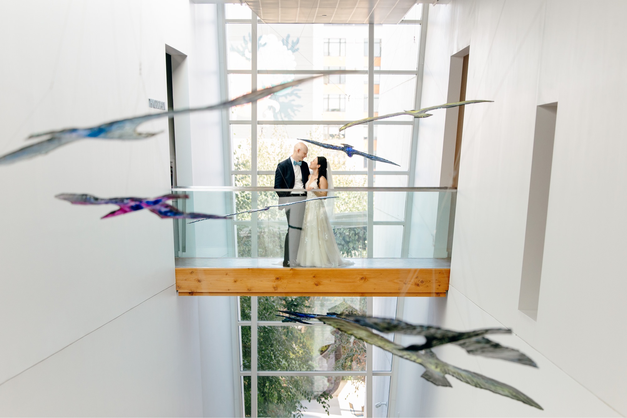 The couple poses for portraits on a walkway in Fjord Hall during their Nordic Museum wedding.