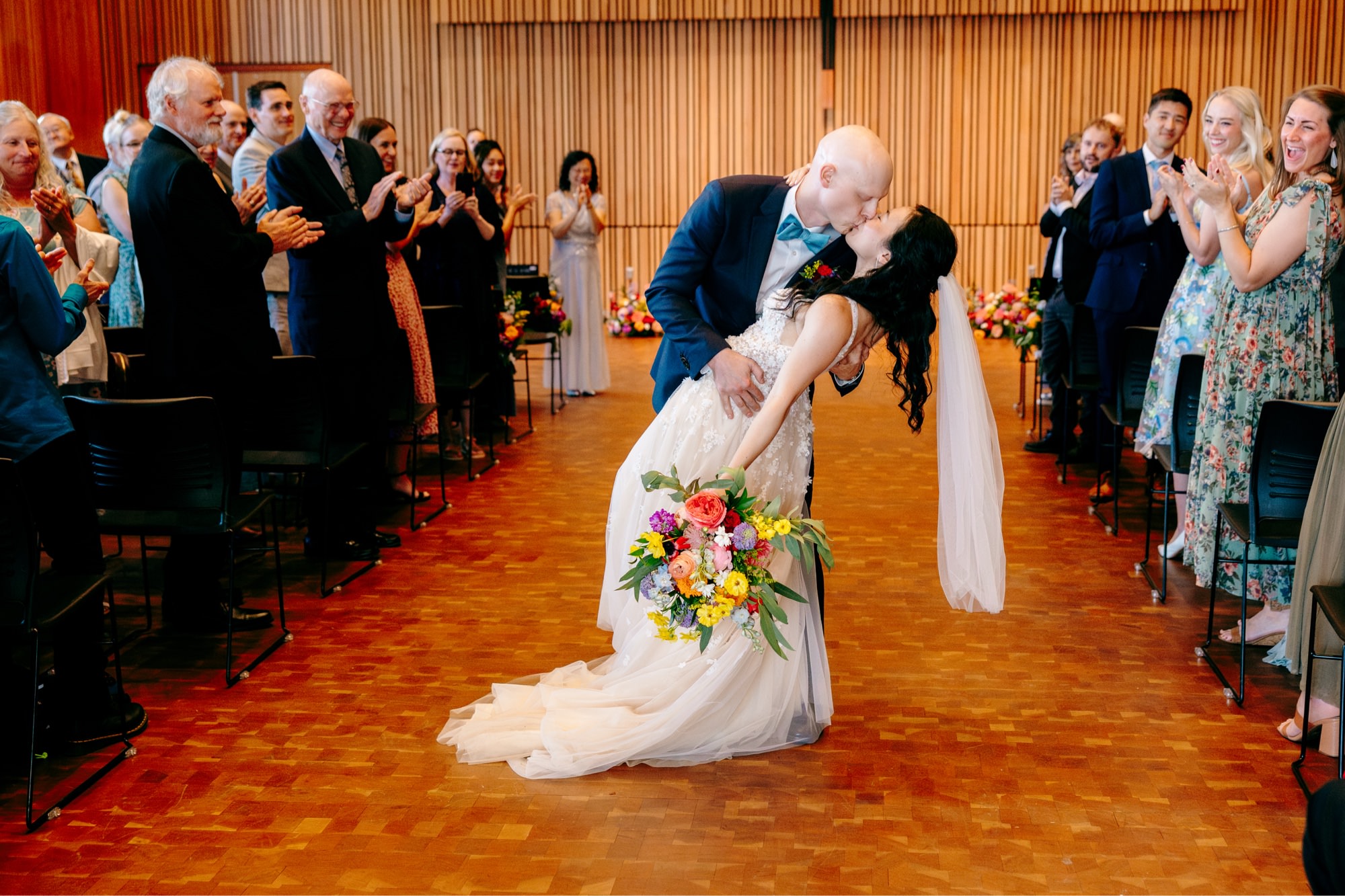 The couple shares a kiss and dip while walking out of their ceremony in Osberg Hall at National Nordic Museum.