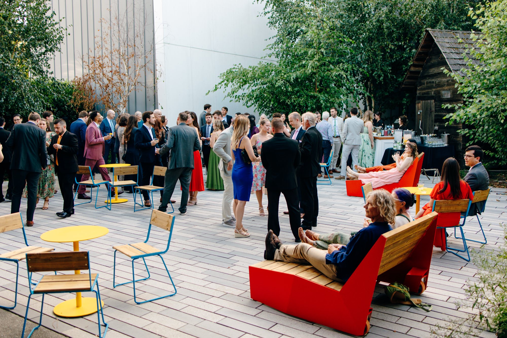 Wedding guests relax and socialize in the East Garden at a National Nordic Museum wedding.
