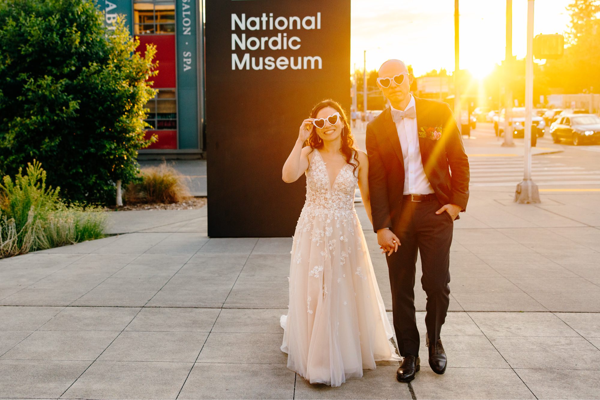 The couple poses in front of the sign for the National Nordic Museum during golden hour.